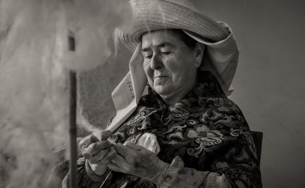 Una imatge en blanc i negre d'una filadora vestida de pagesa, guanyadora del tercer Concurs de Fotografia Festes de Santa Eulària